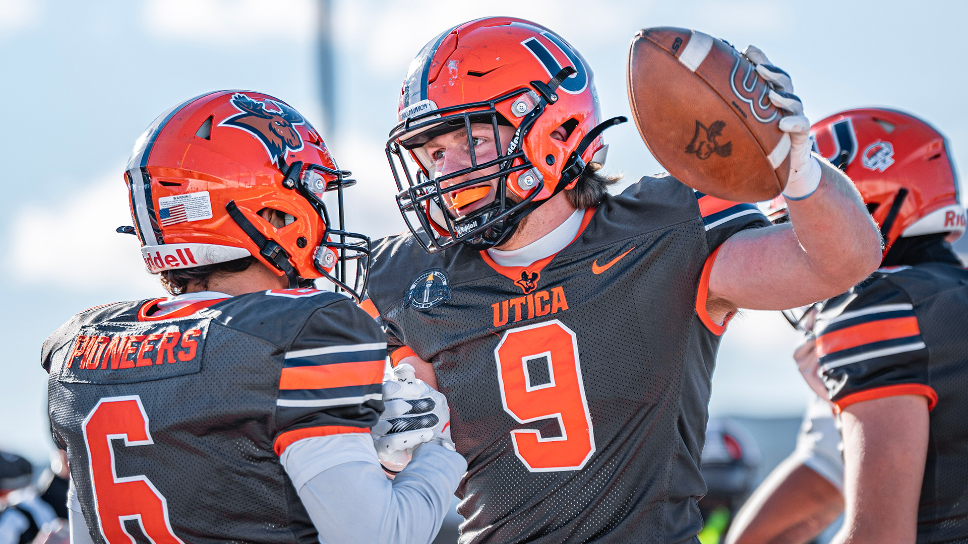 Logan Frederick, right, celebrates with teammate and wide receiver Bryce Palmer on a sunny day.